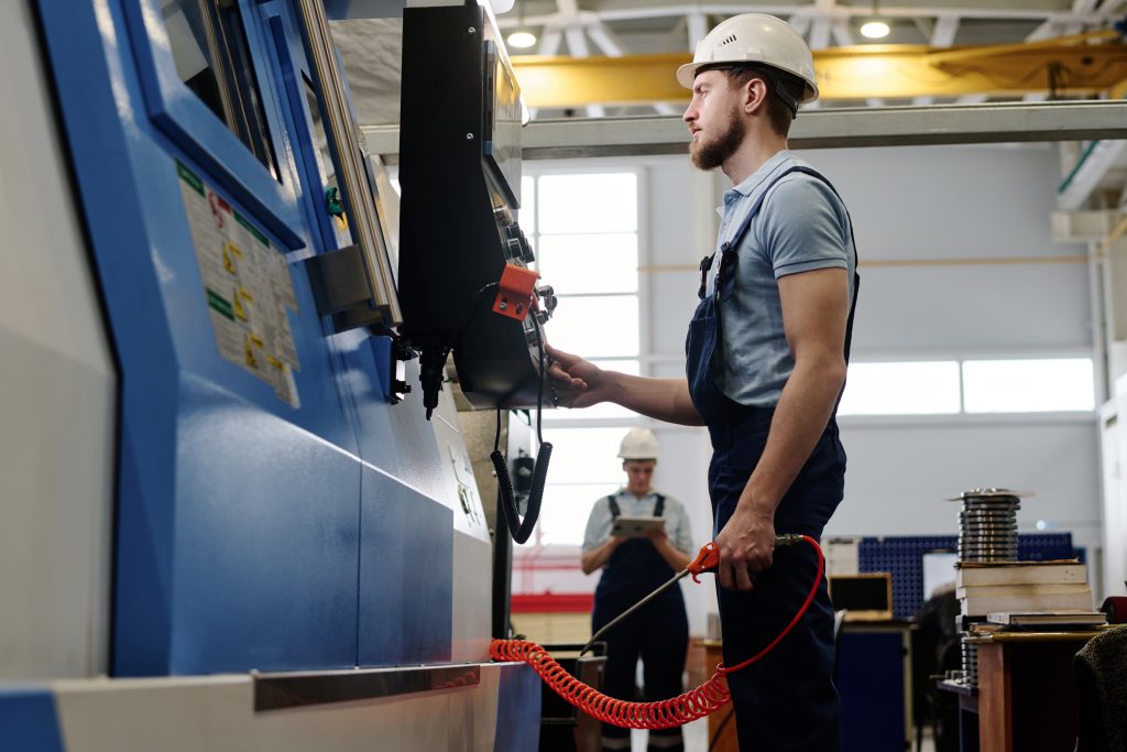 Engineer operating a CNC machine in a factory