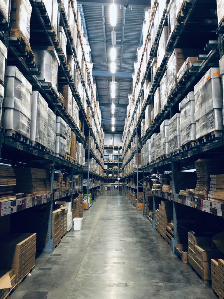 Warehouse aisle with racking stocked to the ceiling