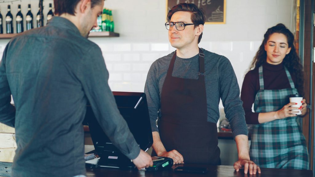 Customer paying by card at a café counter