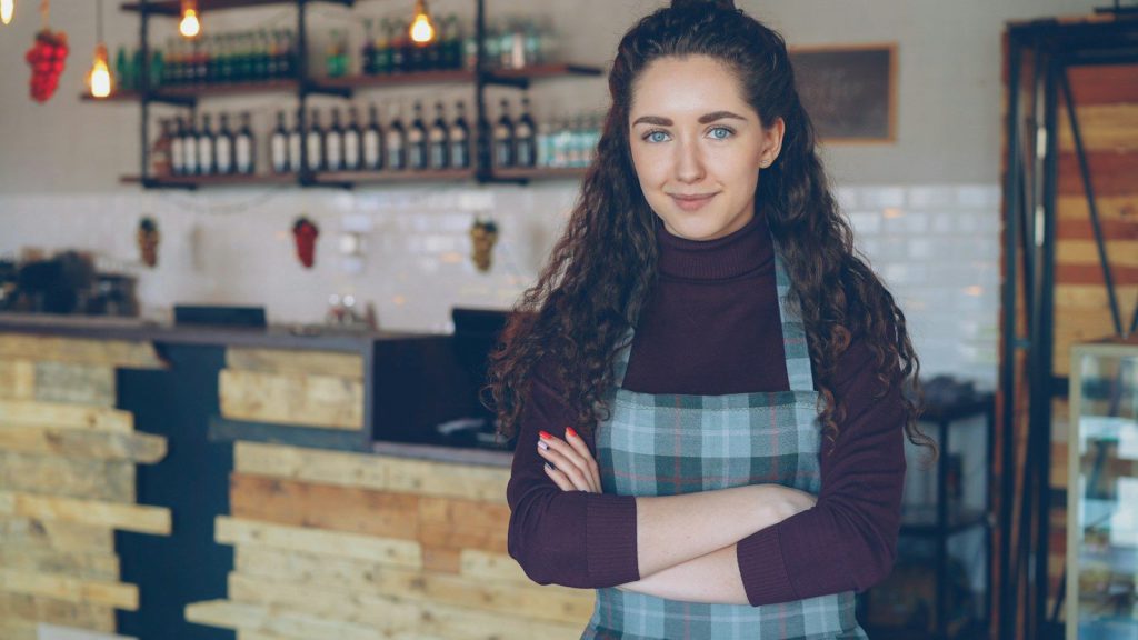 Smiling owner standing in her coffee shop